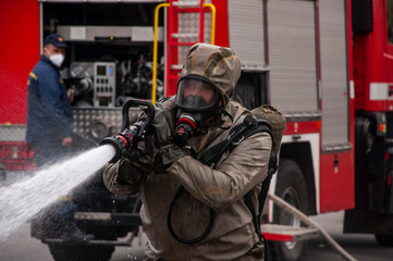 Obraz premium The savior of the fire service disinfects the streets of the city. Preventive methods against coronavirus. Specialist in hazmat suits cleaning disinfecting coronavirus cells epidemic, pandemic health 