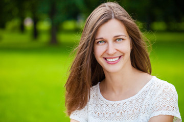 Fototapeta premium Close up portrait of beautiful young happy brunette woman with fresh and clean skin, summer street outdoors