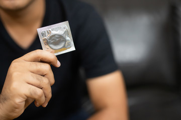 Close up Male hand holding Condom. Safe sex concept.