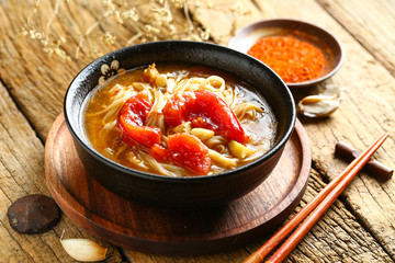tomato noodles in black bowl on wooden table