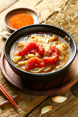 tomato noodles in black bowl on wooden table