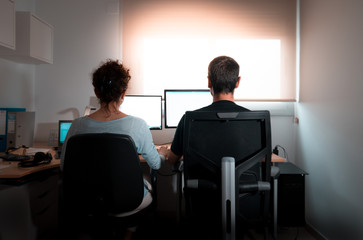 Rear view of a real couple working remotely during the lockdown. Working from home or telecommuting concept