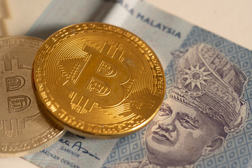 Gold bitcoin coin of malaysia banknote money concept background.