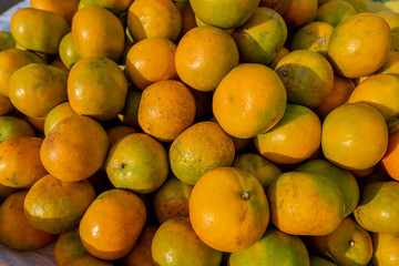 The pile of old oranges for sell in the evening sunlight