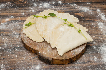 Frozen chebureks on wooden table