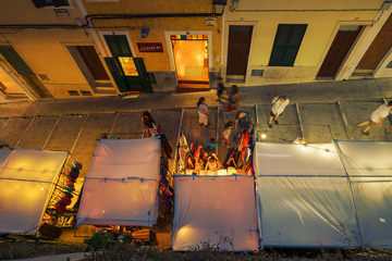 Night view from above of a colorful street market on an alley de Menorca in Spain.