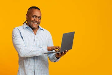 Mature african american man working on laptop online