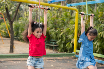 Fototapeta premium happy multi-ethnic children having fun to playing in the playground in summer time with smile and laughing healthy, funny smiling face adorable lovely female kid. happy vacation lifestyle concept.