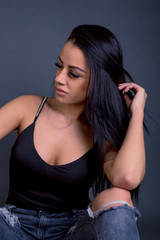 Attractive brunette woman posing to camera in grunge jeans