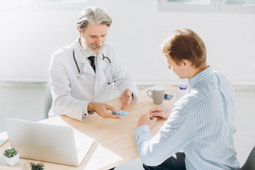Fototapeta premium Patient Having Consultation With Senior Doctor In Office