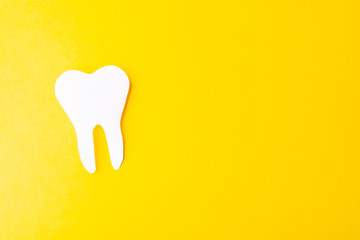 Paper tooth on a yellow background. Place for text