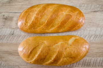 Two loaves on a wooden background. Close-up. White Ukrainian bread.