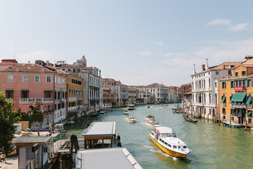 Fototapeta na wymiar Street of Venice in summer time. Italian view. Roof, sea canal, boat in sunny day. Old city, ancient buildings. Italy. Popular tourist destination of Italy. Europe. Venetian canal without people.