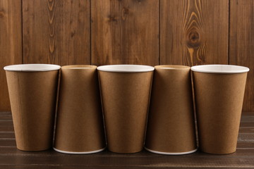 Five eco-friendly cups on a wooden background. The concept of ecology. Mock-up. Close-up.