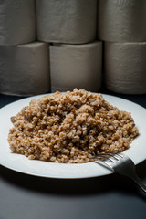 Buckwheat plate on a background of toilet paper