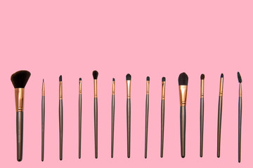 Juego de brochas para maquillaje de diferentes tipos y medidas con fondo rosa