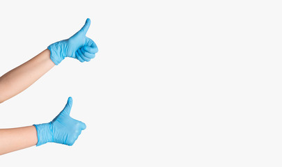 Closeup of female medic in gloves showing thumbs up gesture, isolated on white. Blank space for text or design