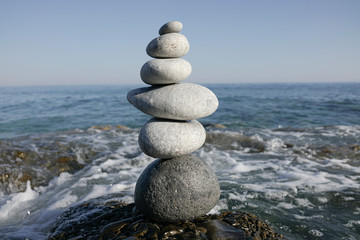 A figure of stones on a background of the sea.