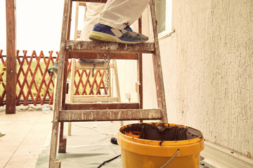 Construction workers plaster a wall.