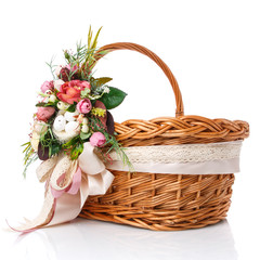 Fototapeta na wymiar Natural wicker basket with flowers and ribbons. Beautiful bow on the side. Isolated