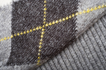 Cozy argyle knitted texture background in grey