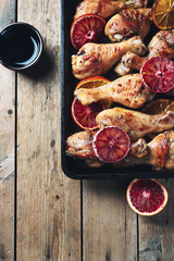 Baked chicken drumstick with orange.