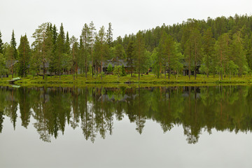 Fototapeta na wymiar Northern landscape with forest lake and mirror reflection. Ruka, Finland