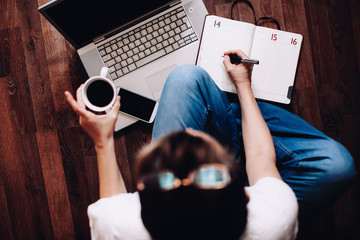 Work from home, woman sitting on the floor at home and working remotely