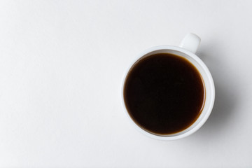 Cup of coffee on white background, top view. White mug of black tea