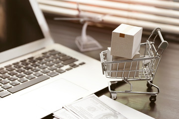 Online shopping concept. paper boxes in shopping cart on  Laptop Computer at home office