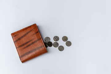 Brown leather men's wallet with Thai baht coins money on white background. -  inequality problem concept.