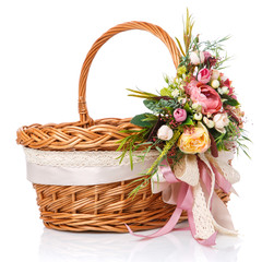 Fototapeta na wymiar Easter basket. Brown wicker basket with colorful floral decor and colored ribbons on a white background.