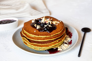 Pancakes with jam, nuts on white table