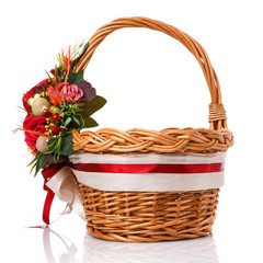 Fototapeta na wymiar Brown wicker basket with original handle. Decor with flowers, eggs and ribbons. Isolated on a white background