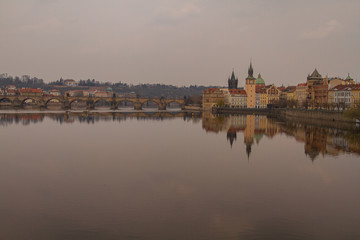 Fototapeta premium view of the river and reflections in it. Old Prague architecture by the river Vltava. In the Czech Republic