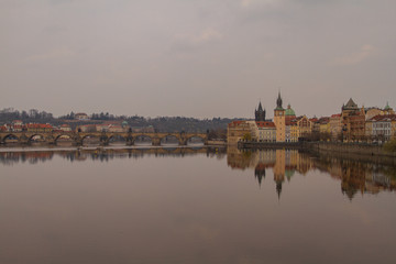 Fototapeta na wymiar view of the river and reflections in it. Old Prague architecture by the river Vltava. In the Czech Republic