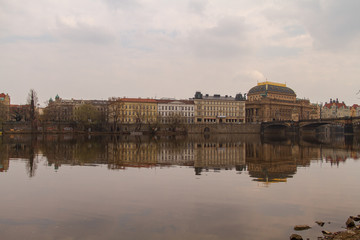 Obraz premium view of the river and reflections in it. Old Prague architecture by the river Vltava. In the Czech Republic