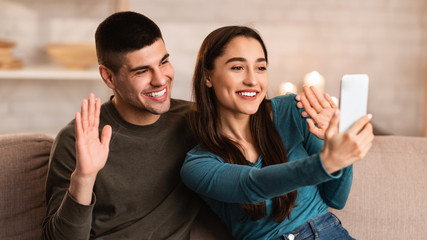 Happy lovely couple making video call on phone at quarantine