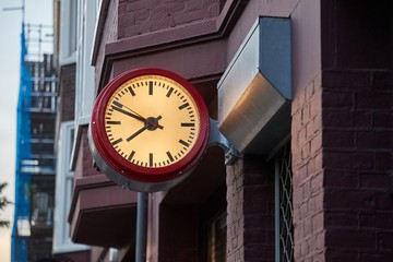 Fototapeta na wymiar Analogue clock on a wall in an urban street