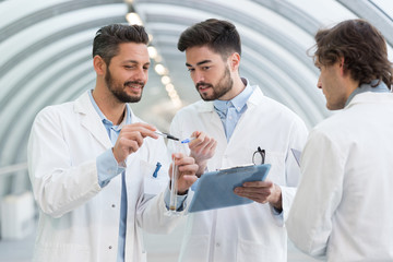 3 engineer men looking at clipboard