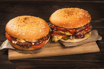 Two big homemade burgers or hamburgers with big roasted meat, close up.