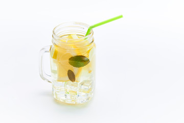 Mason jar glass of lemonade with lemons and straw isolated on a white background.