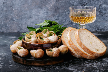 Baked snails with garlic butter and fresh herbs in a frying pan, selective focus