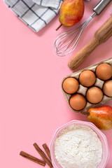 Different ingredients for baking lined  on a pink background flat lay.
