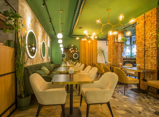 Roomy hall in restaurant or cafe with wooden furniture and walls of red bricks