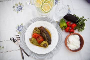 Eggplants are stuffed with meat lamb and rice. Patlican . eggplant filling . Eggplant, peppers, tomatoes . Yogurt in a brown bowl . Chopped lemon in a glass jar . Stuffed eggplant in the plate .