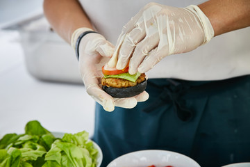 Preparing burger adding vegetable and sauce. cooking,