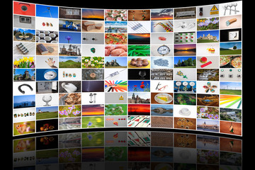 Zakrzywiona ściana z ekranów TV z różnorodnymi motywami na czarnym tle © Rafał Rębacz