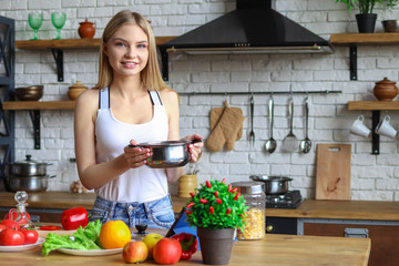 Girl in the kitchen with a pot of soup, cooking at home
