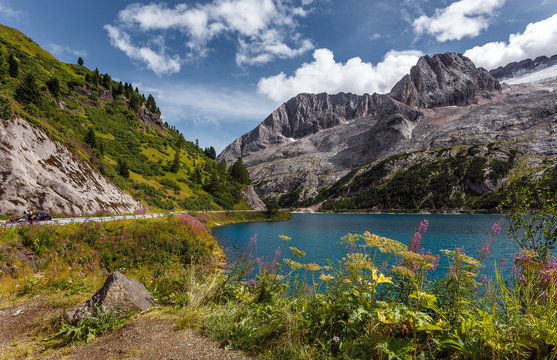 Amazing natural scenery in Dolomites Alps.  Summer view of  Fedaia lake and Marmolada mountain. Picture of wild area. Awesome alpine highland in sunny day